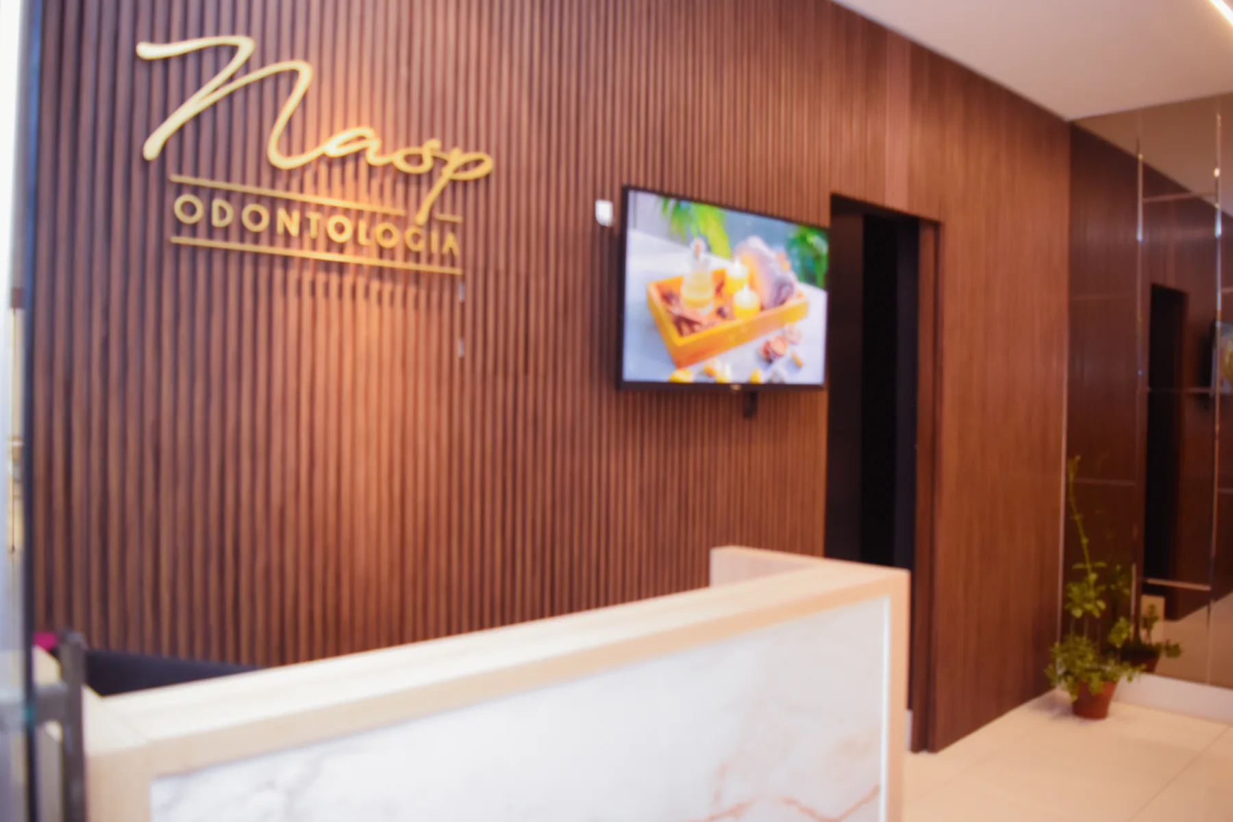 Recepção da NASP Odontologia com o letreiro dourado da marca